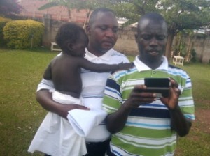 Hosea Sempa from our training team holds a mothers baby so she can participate in the training